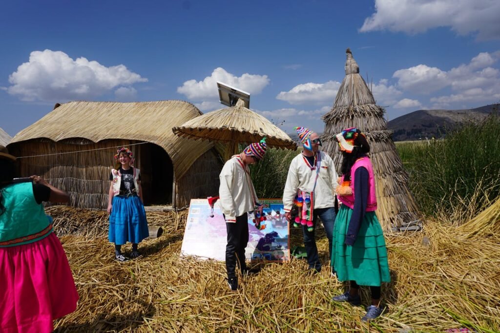 Group of people on Uros islands wearing traditional Andean clothing under a bright sky.